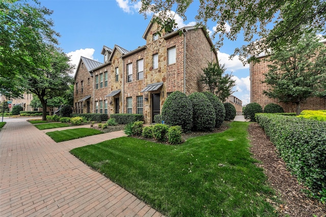 7941 Parkwood Blvd, Plano, TX 75024 - townhome / multi-family property featuring brick siding, a front yard, a standing seam roof, and metal roof