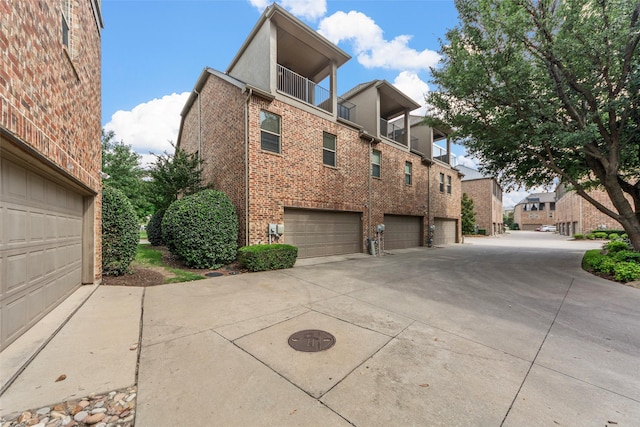 7941 Parkwood Blvd, Plano, TX 75024 - view of property exterior with driveway, brick siding, a garage, and a residential view