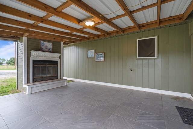 560 N Cardinal Rd, Reno, TX 76020 - unfurnished living room featuring a glass covered fireplace and wood walls