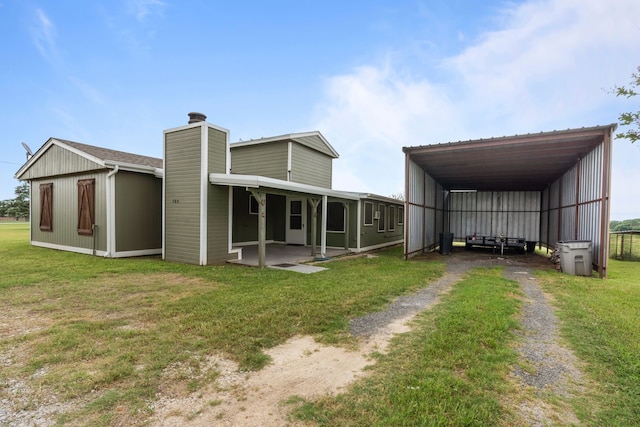 560 N Cardinal Rd, Reno, TX 76020 - rear view of house with dirt driveway, a yard, a carport, and a chimney