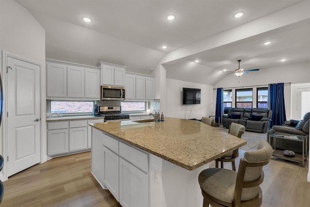 716 Newberry Ln, Royse City, TX 75189 - kitchen featuring stainless steel appliances, lofted ceiling, light wood-type flooring, decorative backsplash, and ceiling fan