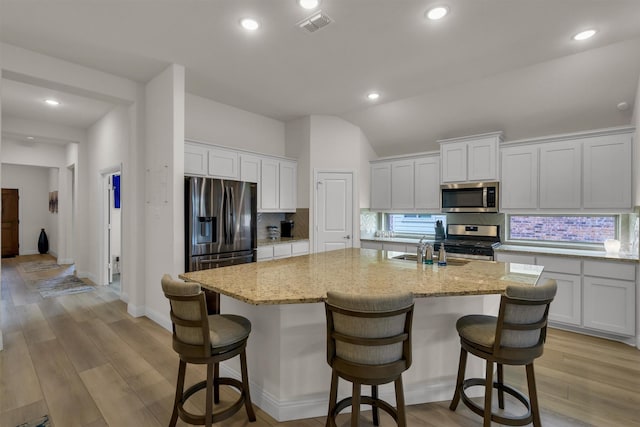 716 Newberry Ln, Royse City, TX 75189 - kitchen featuring appliances with stainless steel finishes, decorative backsplash, a kitchen island with sink, recessed lighting, and vaulted ceiling
