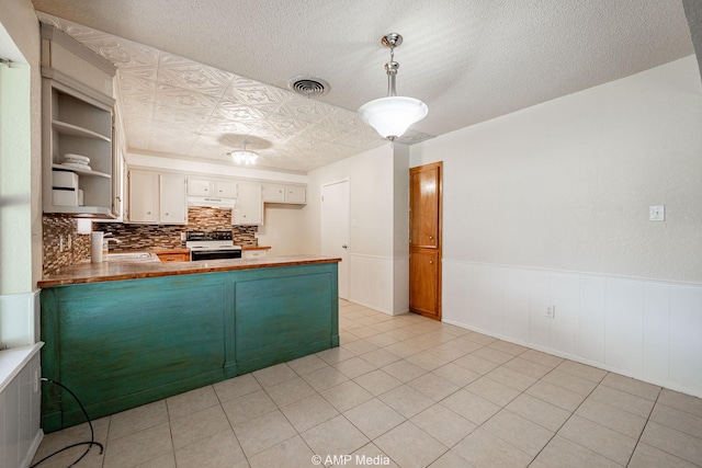 3226 Whitewing Way, Abilene, TX 79606 - kitchen featuring electric stove, wainscoting, a peninsula, decorative backsplash, and a sink