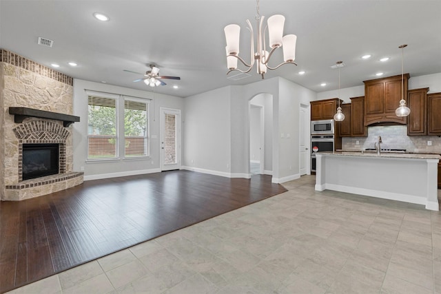 14824 Belclaire Ave, Aledo, TX 76008 - kitchen with stainless steel appliances, open floor plan, arched walkways, a ceiling fan, and light countertops