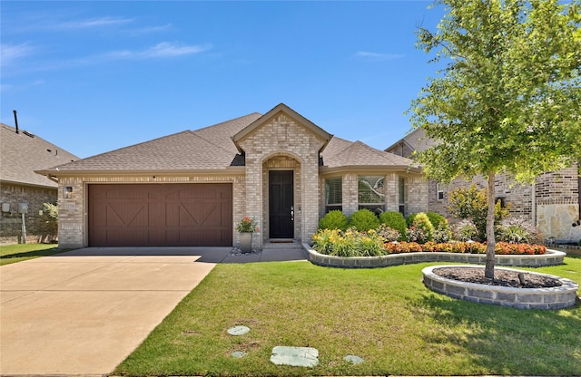 3708 Bennett Trl, Celina, TX 75009 - french country style house featuring brick siding, a front yard, a garage, driveway, and roof with shingles
