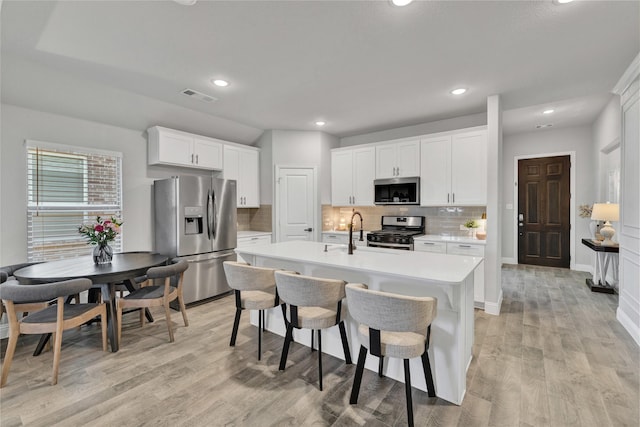 3708 Bennett Trl, Celina, TX 75009 - kitchen featuring stainless steel appliances, backsplash, light countertops, light wood-style floors, and a center island with sink