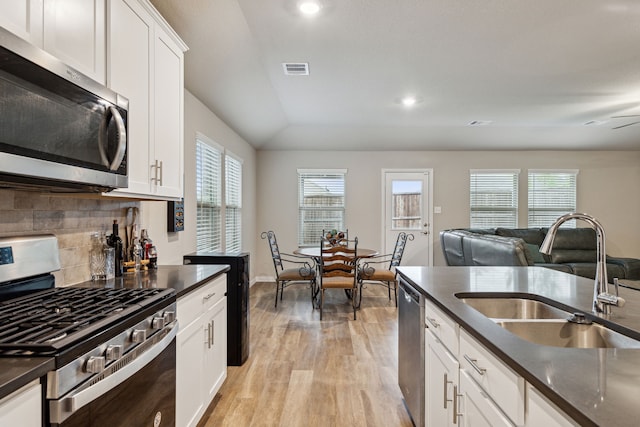 263 Hawthorn Dr, Lavon, TX 75166 - kitchen featuring appliances with stainless steel finishes, a sink, dark countertops, tasteful backsplash, and light wood finished floors