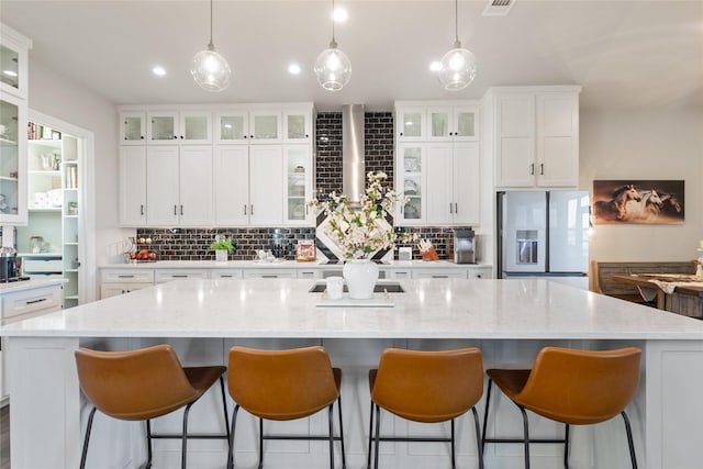 7608 N Branch Rd, Krum, TX 76249 - kitchen with stainless steel refrigerator with ice dispenser, decorative backsplash, a spacious island, white cabinetry, and pendant lighting