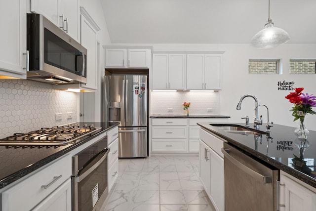 1309 Haybale Ln, Garland, TX 75042 - kitchen featuring appliances with stainless steel finishes, a sink, light marble finish floors, dark stone countertops, and white cabinets