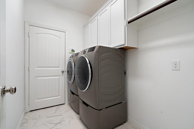 1309 Haybale Ln, Garland, TX 75042 - washroom with washer and clothes dryer, cabinet space, baseboards, and light marble finish flooring