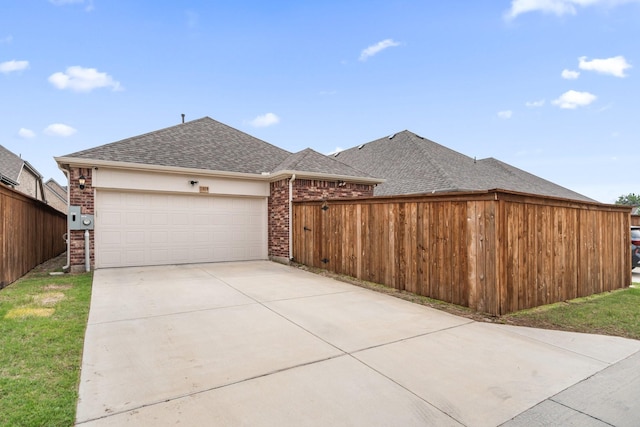 1309 Haybale Ln, Garland, TX 75042 - view of side of home featuring an attached garage, concrete driveway, fence, a shingled roof, and brick siding