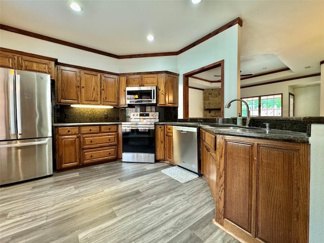 118 Hacienda Dr, Pottsboro, TX 75076 - kitchen featuring stainless steel appliances, brown cabinets, a peninsula, tasteful backsplash, and light wood finished floors