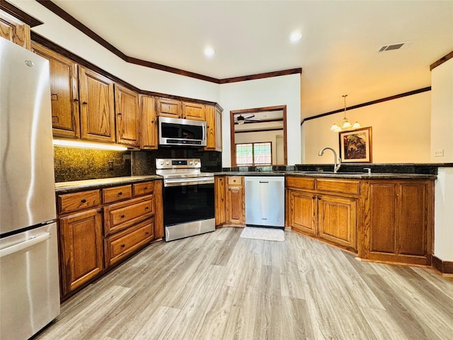 118 Hacienda Dr, Pottsboro, TX 75076 - kitchen featuring stainless steel appliances, brown cabinetry, crown molding, dark countertops, and recessed lighting