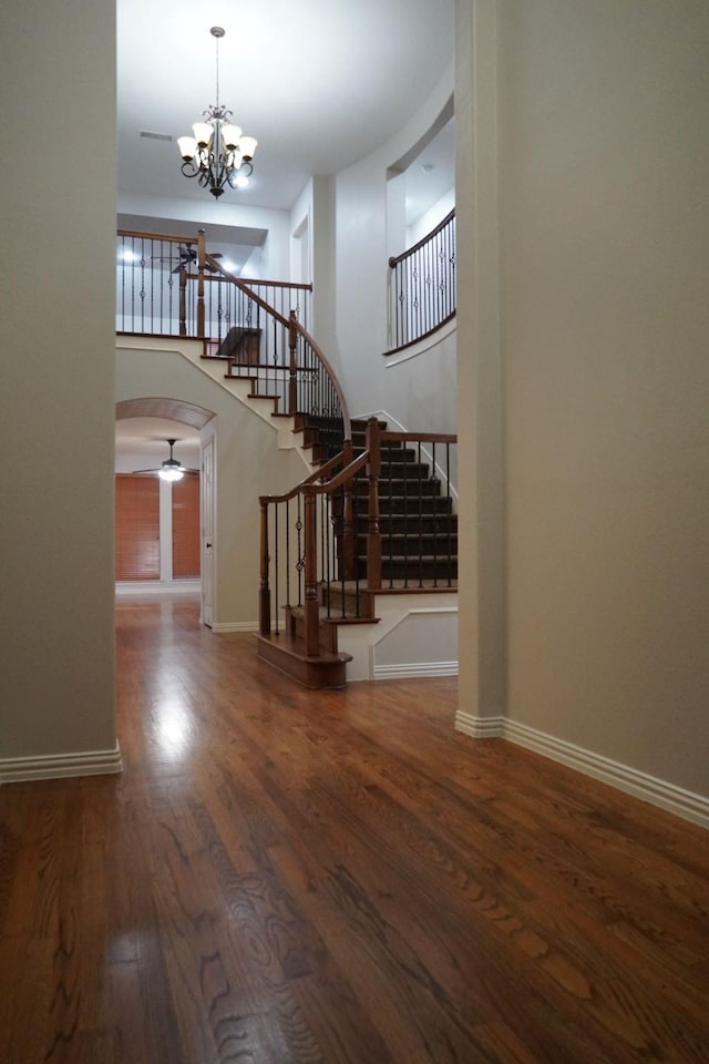 1136 Philip Dr, Allen, TX 75013 - stairway featuring a chandelier, wood finished floors, arched walkways, and baseboards