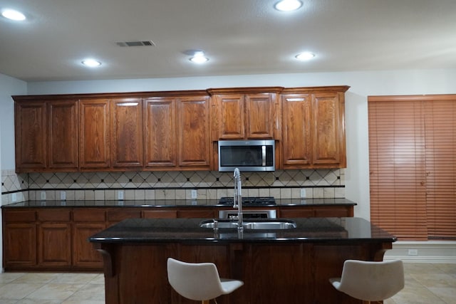 1136 Philip Dr, Allen, TX 75013 - kitchen featuring stainless steel microwave, dark countertops, a breakfast bar area, backsplash, and recessed lighting