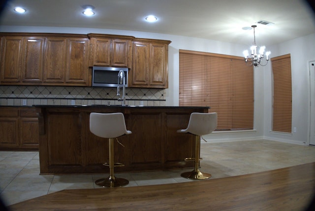 1136 Philip Dr, Allen, TX 75013 - kitchen with stainless steel microwave, dark countertops, a chandelier, pendant lighting, and recessed lighting