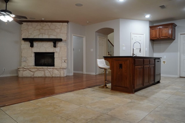 1136 Philip Dr, Allen, TX 75013 - kitchen with ceiling fan, dark countertops, arched walkways, open floor plan, and light wood-style flooring