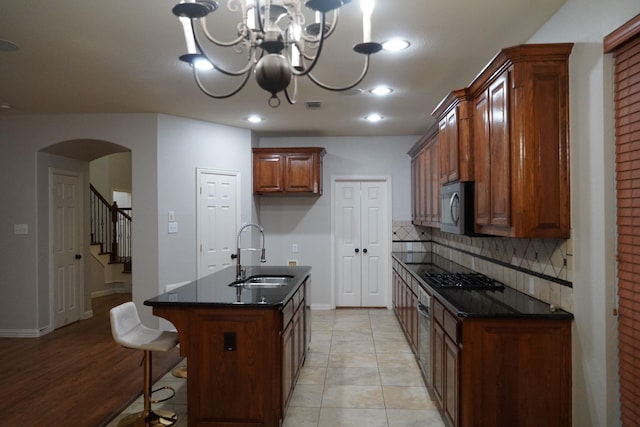 1136 Philip Dr, Allen, TX 75013 - kitchen featuring a sink, tasteful backsplash, arched walkways, a chandelier, and black cooktop