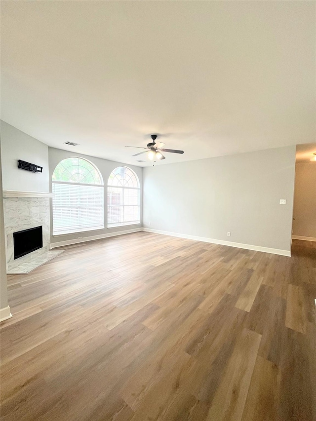 922 Mustang Dr, Allen, TX 75002 - unfurnished living room with ceiling fan, a fireplace, light wood-type flooring, and baseboards