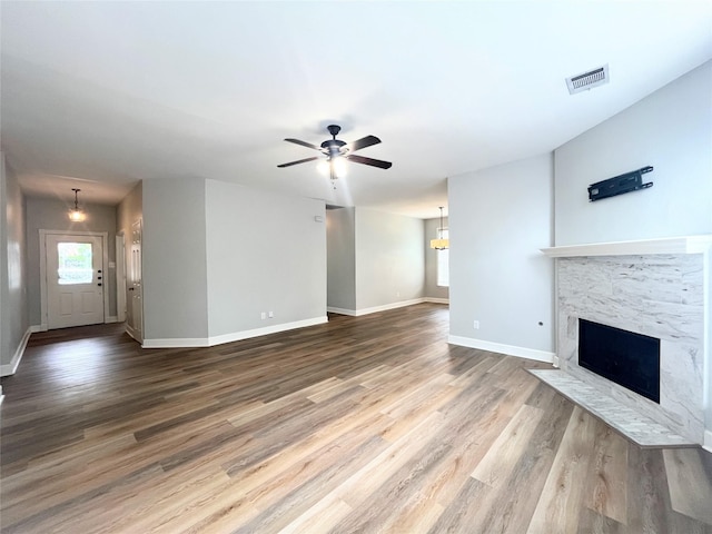 922 Mustang Dr, Allen, TX 75002 - unfurnished living room with a high end fireplace, a ceiling fan, baseboards, and wood finished floors