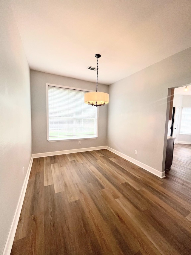 922 Mustang Dr, Allen, TX 75002 - unfurnished dining area featuring a chandelier, dark wood-type flooring, and baseboards