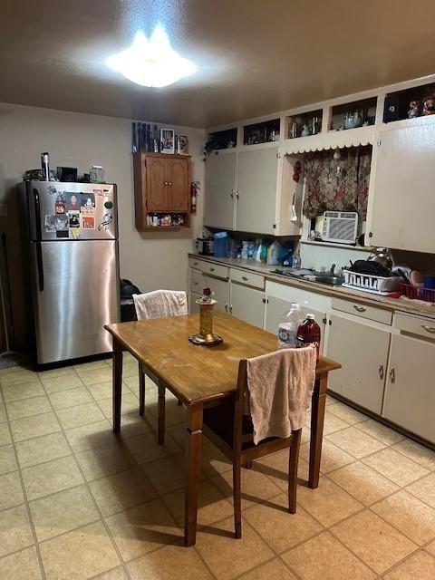 1505 S Austin St, Sherman, TX 75090 - kitchen with freestanding refrigerator, cooling unit, and white cabinetry