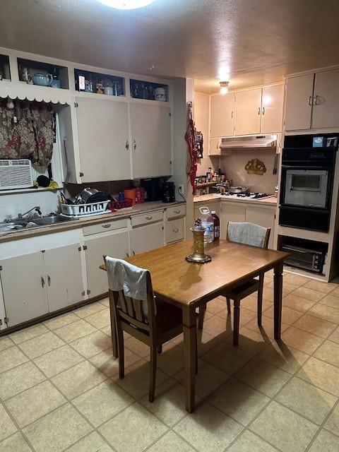 1505 S Austin St, Sherman, TX 75090 - kitchen with oven, under cabinet range hood, a sink, white cabinets, and white gas cooktop