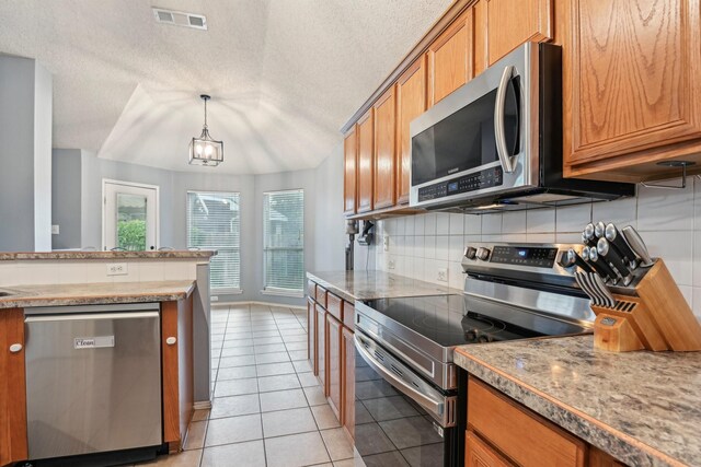 5729 Brazos Dr, Haltom City, TX 76137 - kitchen with appliances with stainless steel finishes, brown cabinets, backsplash, light tile patterned floors, and hanging light fixtures
