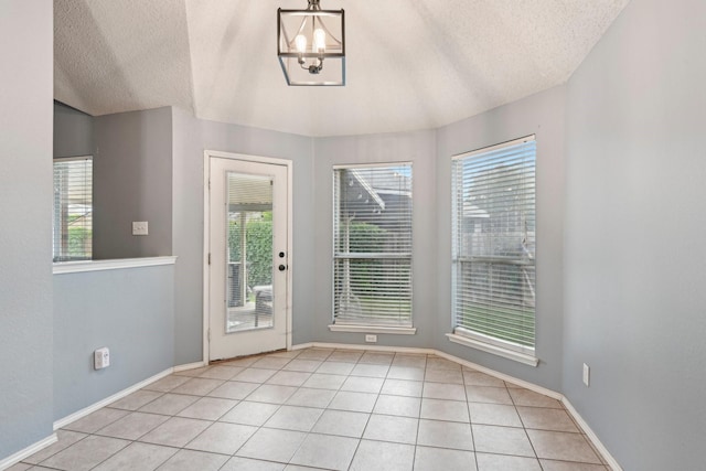 5729 Brazos Dr, Haltom City, TX 76137 - unfurnished dining area with plenty of natural light, a textured ceiling, a chandelier, light tile patterned floors, and baseboards
