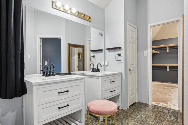 5729 Brazos Dr, Haltom City, TX 76137 - bathroom with vanity, a spacious closet, and stone finish floors