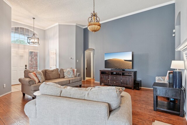 5729 Brazos Dr, Haltom City, TX 76137 - living area with hardwood / wood-style flooring, a chandelier, arched walkways, crown molding, and a textured ceiling