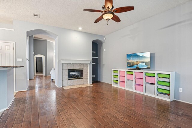 5729 Brazos Dr, Haltom City, TX 76137 - unfurnished living room featuring ceiling fan, wood finished floors, a fireplace, a textured ceiling, and baseboards