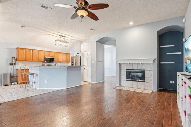 5729 Brazos Dr, Haltom City, TX 76137 - kitchen with appliances with stainless steel finishes, open floor plan, a ceiling fan, a textured ceiling, and vaulted ceiling