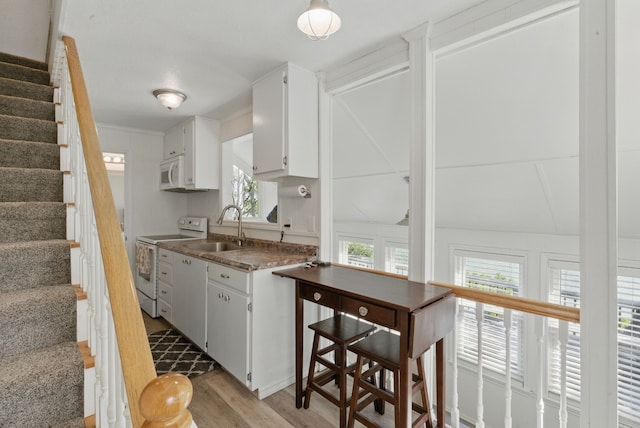 306 Chism Trl, Gordon, TX 76453 - kitchen featuring white appliances, a sink, light wood-style floors, and plenty of natural light