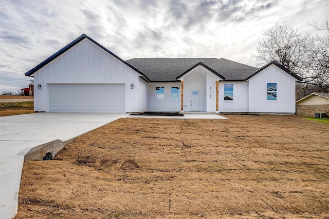 171 Tryall Ct, Runaway Bay, TX 76426 - modern farmhouse featuring a garage, concrete driveway, board and batten siding, and a shingled roof