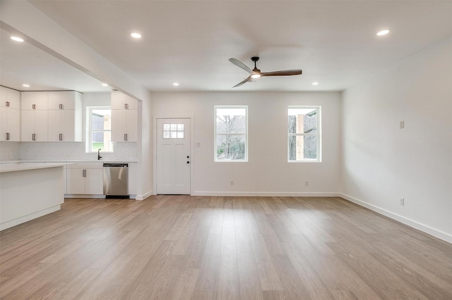 171 Tryall Ct, Runaway Bay, TX 76426 - unfurnished living room featuring ceiling fan, light wood-type flooring, recessed lighting, baseboards, and a sink