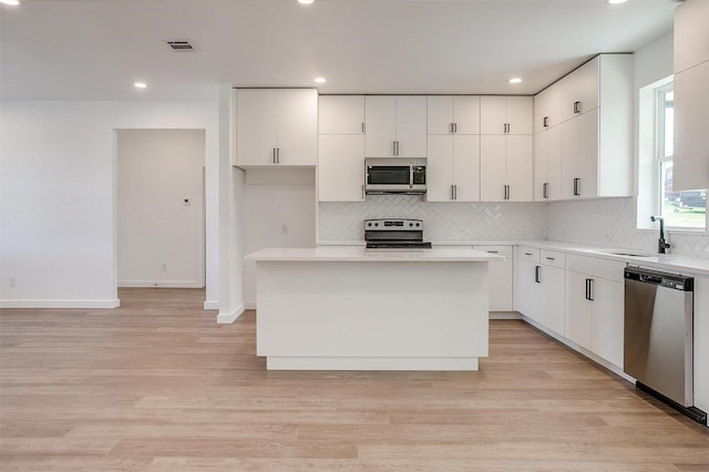 171 Tryall Ct, Runaway Bay, TX 76426 - kitchen with appliances with stainless steel finishes, tasteful backsplash, a sink, white cabinetry, and recessed lighting