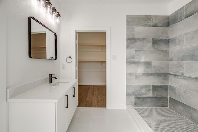 171 Tryall Ct, Runaway Bay, TX 76426 - bathroom with a walk in closet, a tile shower, tile patterned flooring, and vanity