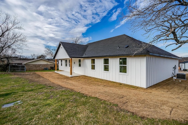 171 Tryall Ct, Runaway Bay, TX 76426 - rear view of house featuring board and batten siding, cooling unit, a patio, a lawn, and a shingled roof