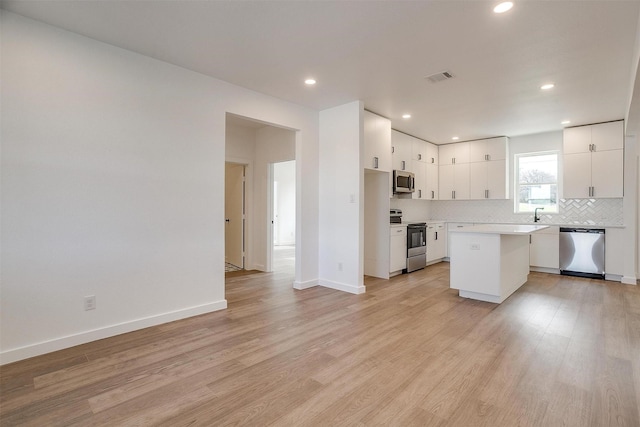 171 Tryall Ct, Runaway Bay, TX 76426 - kitchen with stainless steel appliances, tasteful backsplash, a kitchen island, recessed lighting, and light wood-style floors
