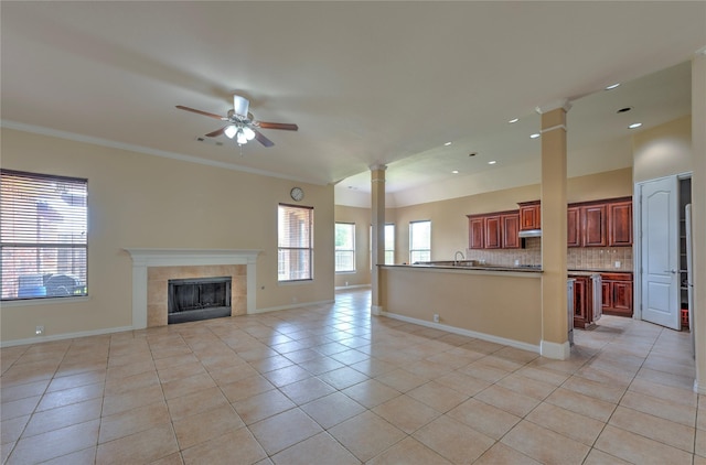 319 Paloverde Ln, Frisco, TX 75036 - unfurnished living room featuring light tile patterned floors, ornate columns, a ceiling fan, baseboards, and crown molding