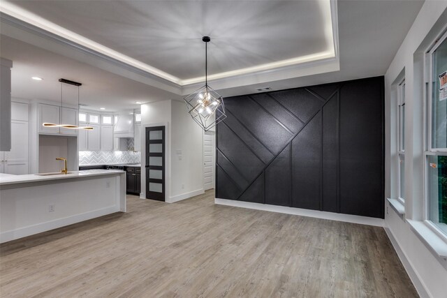 2614 Ave G, Fort Worth, TX 76105 - unfurnished dining area featuring light wood-style flooring, baseboards, a tray ceiling, a sink, and recessed lighting