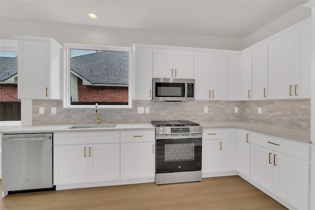 1529 Harvest Run Dr, Allen, TX 75002 - kitchen featuring appliances with stainless steel finishes, a sink, white cabinetry, recessed lighting, and light countertops