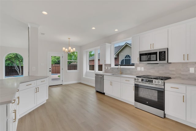 1529 Harvest Run Dr, Allen, TX 75002 - kitchen with appliances with stainless steel finishes, a sink, a chandelier, light wood-style flooring, and recessed lighting