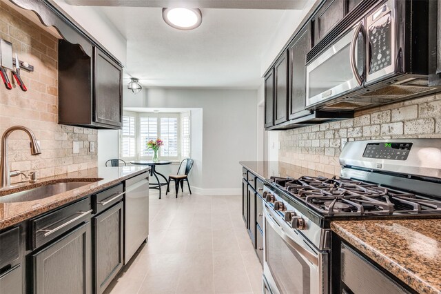 3210 Brincrest Dr, Farmers Branch, TX 75234 - kitchen featuring stainless steel appliances, a sink, dark stone countertops, baseboards, and backsplash