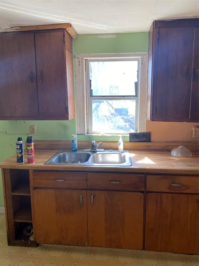 303 Pecan St, Bardwell, TX 75101 - kitchen featuring a sink, light floors, light countertops, brown cabinets, and open shelves