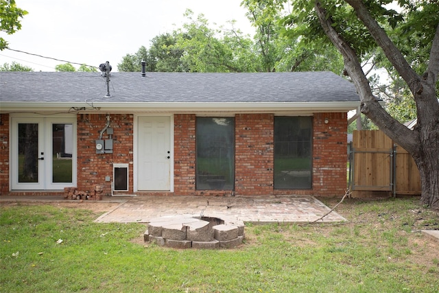 1413 Oak Hills Dr, Graham, TX 76450 - rear view of property featuring a lawn, a patio area, roof with shingles, and brick siding