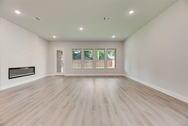 7111 Manhattan Dr, Rowlett, TX 75088 - unfurnished living room with wood finished floors, baseboards, recessed lighting, and a glass covered fireplace