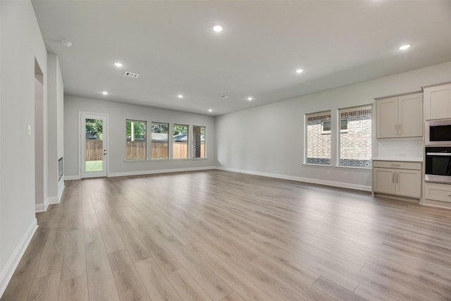 7111 Manhattan Dr, Rowlett, TX 75088 - unfurnished living room with light wood-type flooring, recessed lighting, and baseboards