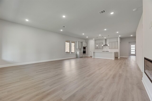 7111 Manhattan Dr, Rowlett, TX 75088 - unfurnished living room featuring light wood-type flooring, recessed lighting, baseboards, and healthy amount of natural light
